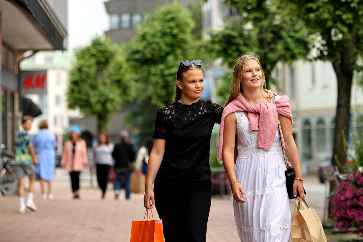 Två tjejer går med shoppingkassar genom centrala Vetlanda.