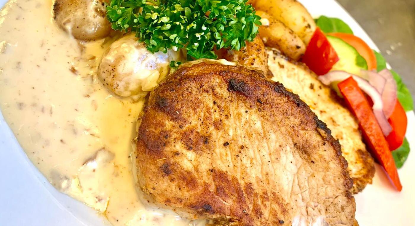 En tallrik med kött, potatis och grönsaker