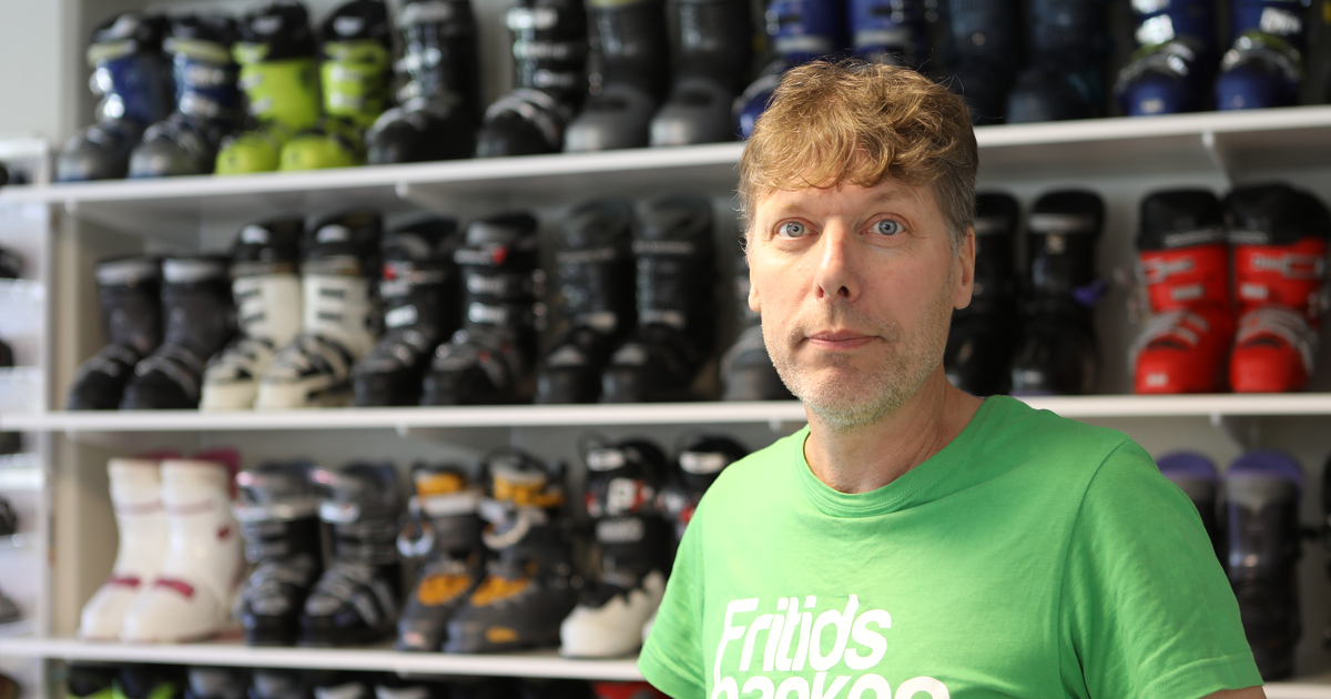 Man med Fritidsbankens logotyp på bröstet står framför hyllor med rader av slalompjäxor