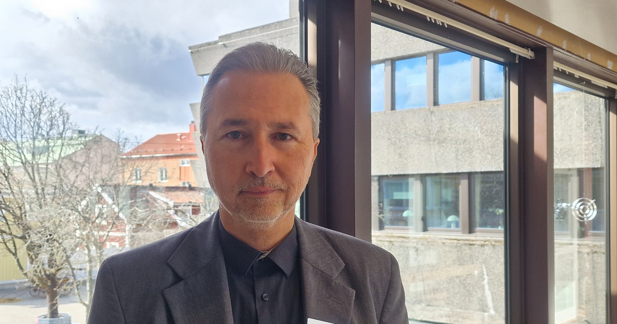 Person med träd och hus i bakgrunden.