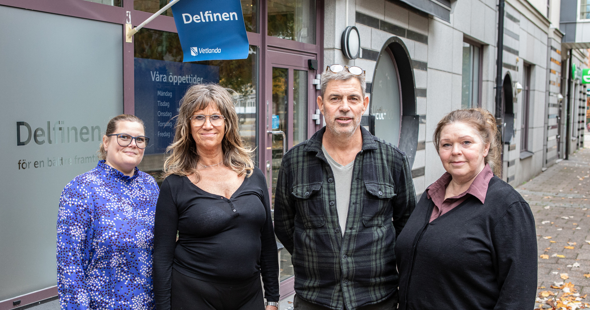 En grupp människor som står bredvid varandra framför en ingången till Delfnen.