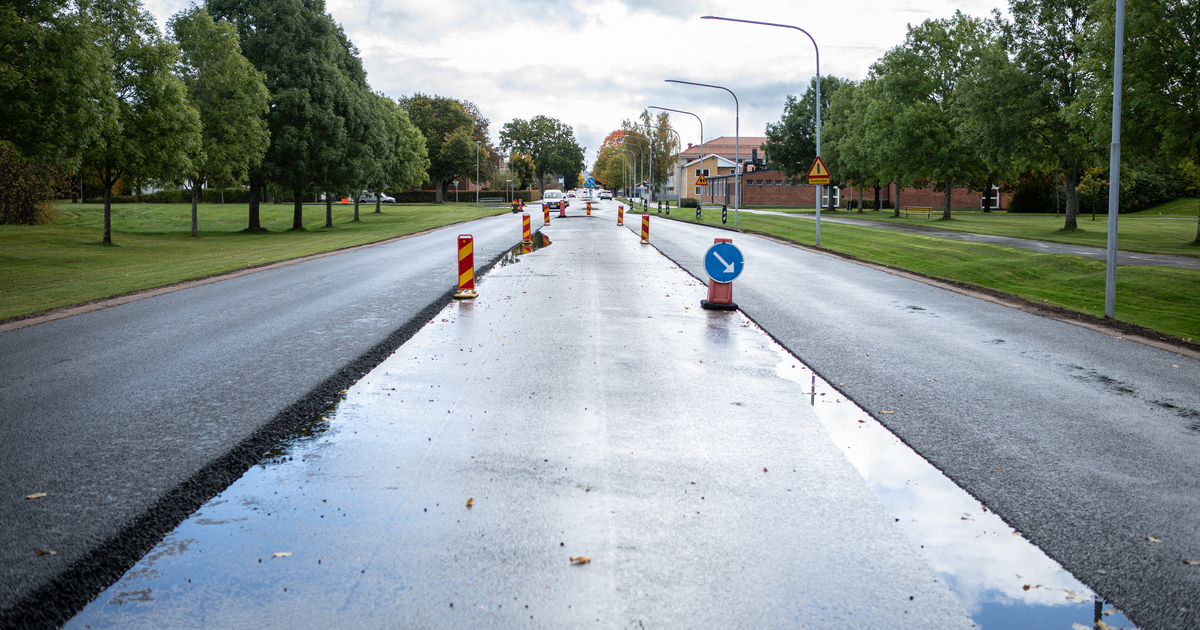 Nyasfalterade körfält på varsin sida om en avstängd yta av en bred väg.