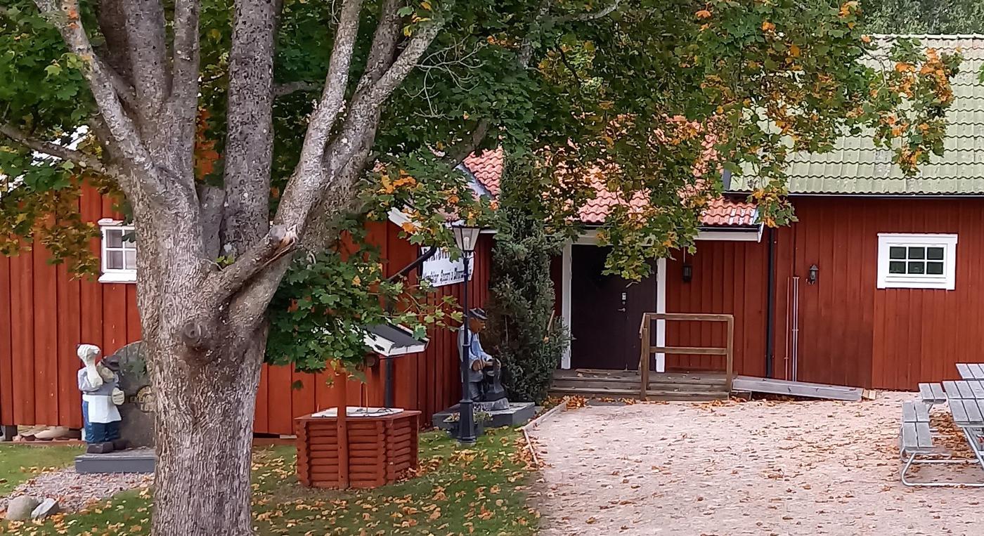 Ett träd framför entrén till industrimuseets röda byggnad.