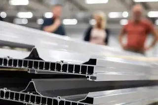 Suddiga personer ser ut att prata med varandra bakom en aluminiumprofil