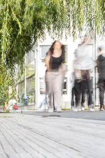 Suddiga personer rör sig längs ett promenadstråk